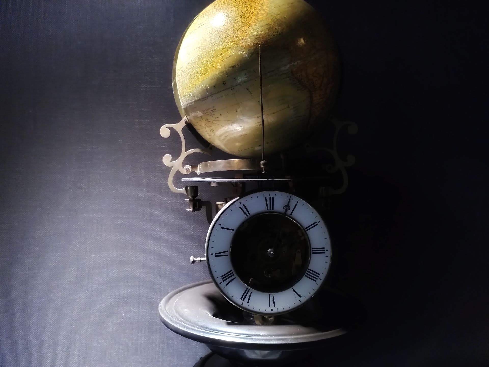 A mechanical globe, showing the path of the sun around the world, with clock underneath.