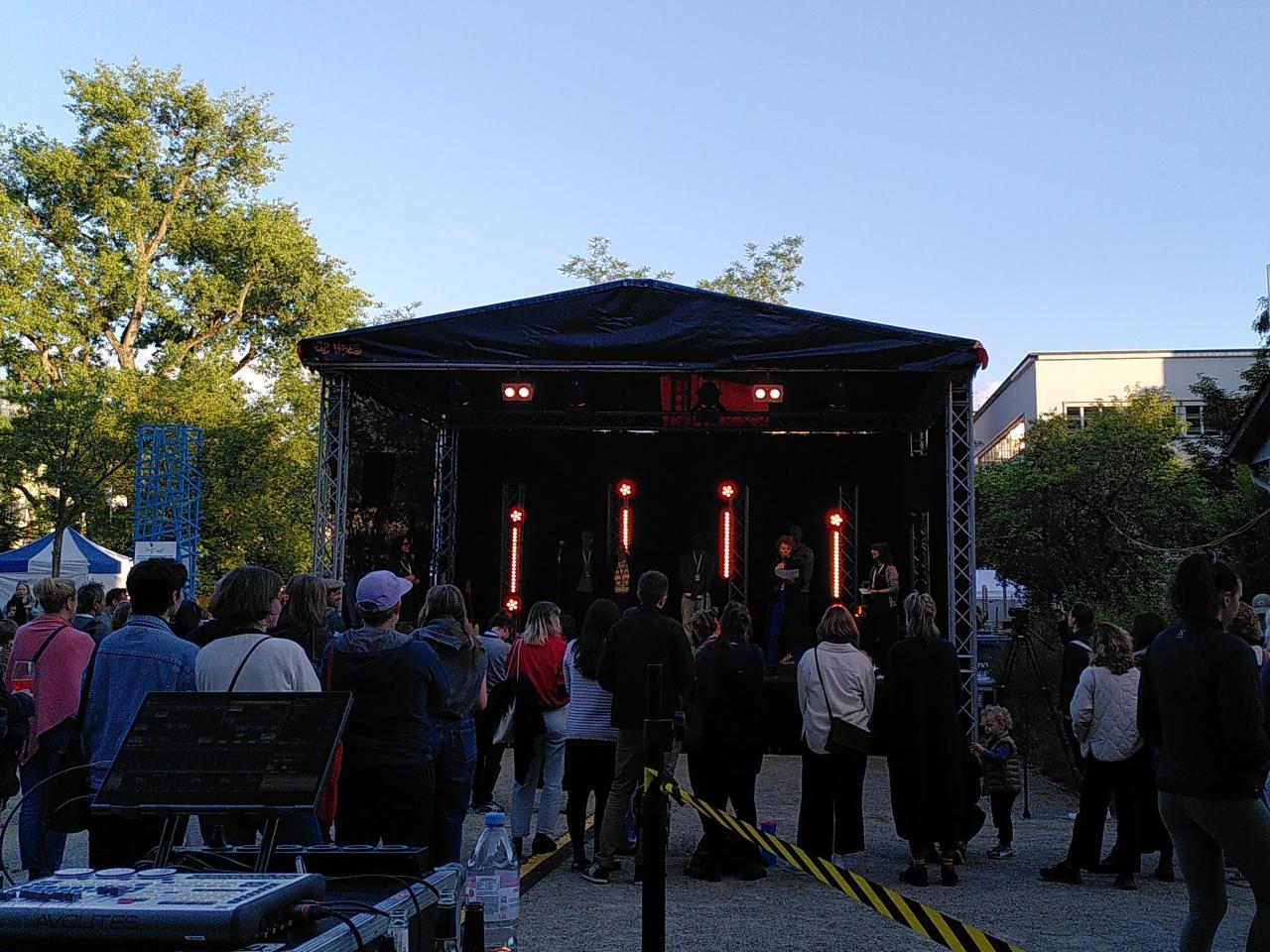 A stage with a crowd of people standing in front